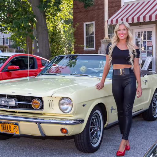 Photo 4: a woman next to a pale yellow Mustang convertible on a street